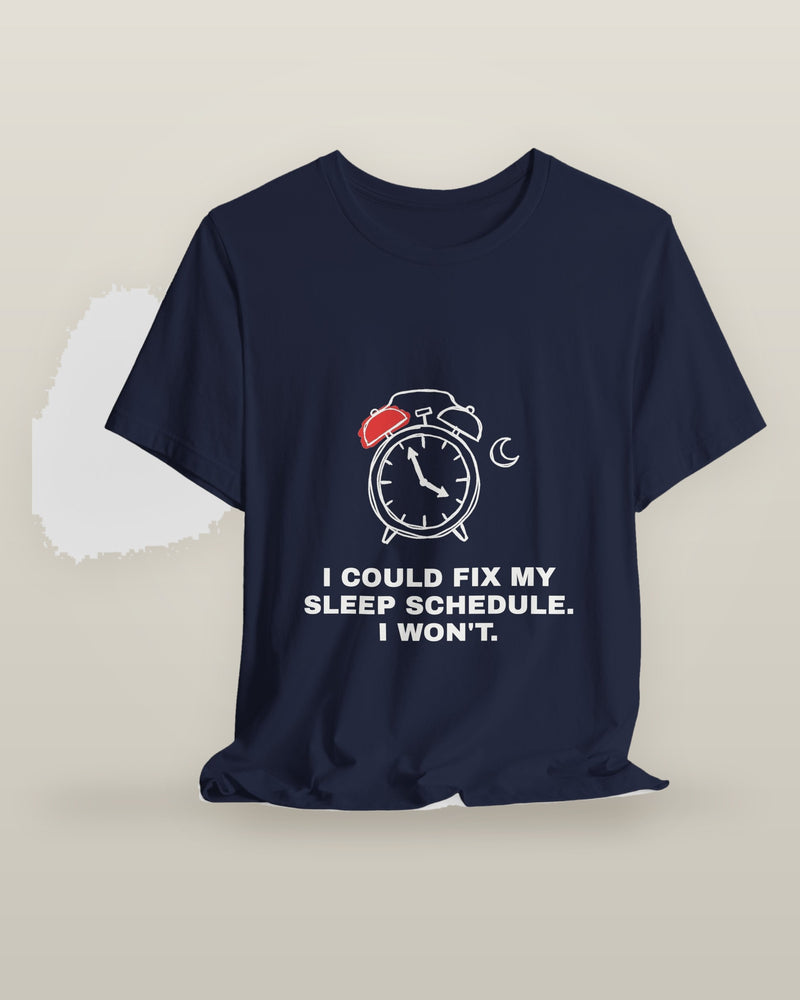 I could fix my sleep schedule. I won't. — an alarm clock at a very late hour beside a crescent moon, printed on a navy cotton t-shirt, on a hanger