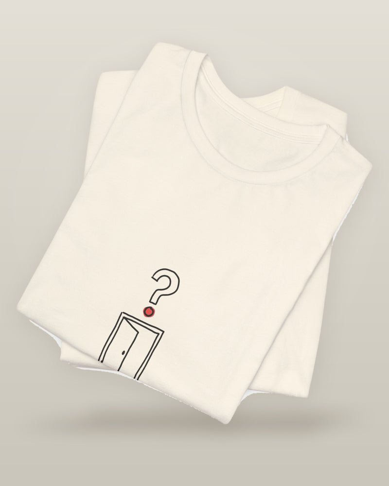 I came, I saw, I forgot why — an empty doorway with a question mark above it, printed on a natural cream cotton t-shirt, folded