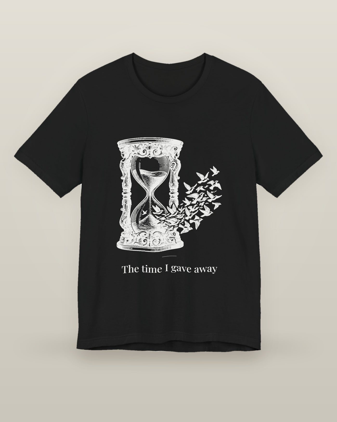 The time I gave away — an hourglass whose falling sand becomes a flock of birds, printed on a black cotton t-shirt, front view