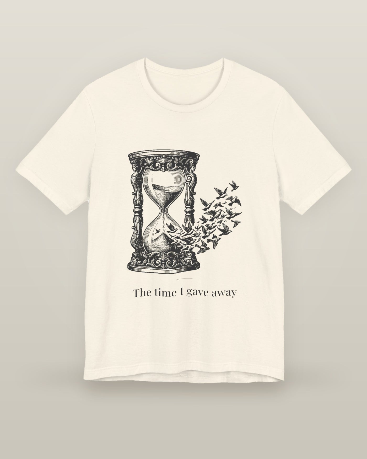The time I gave away — an hourglass whose falling sand becomes a flock of birds, printed on a natural cream cotton t-shirt, front view