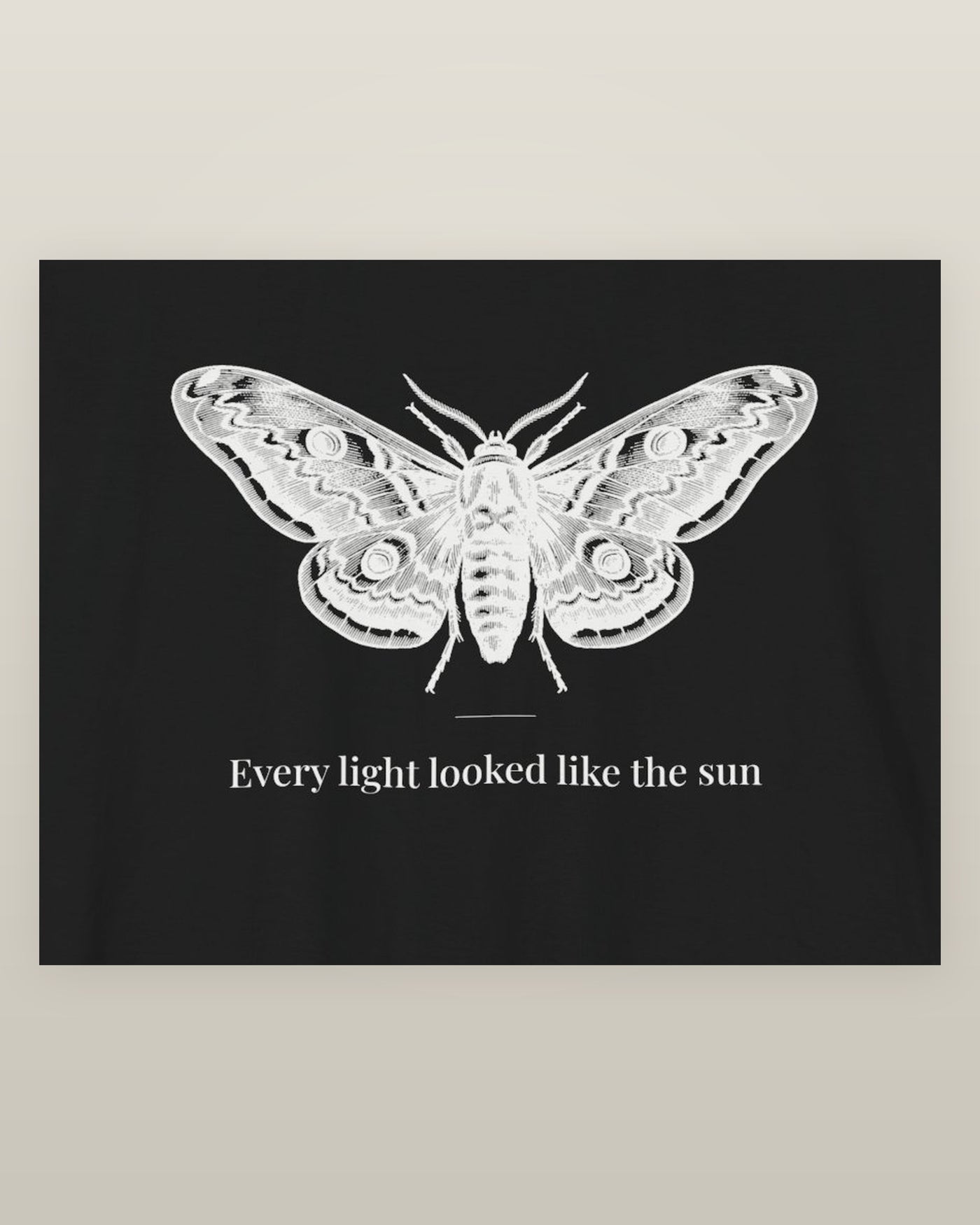 Every light looked like the sun — a moth specimen study, wings spread, printed on a black cotton t-shirt, close detail of the print