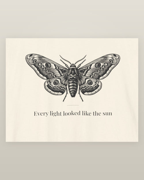 Every light looked like the sun — a moth specimen study, wings spread, printed on a natural cream cotton t-shirt, close detail of the print