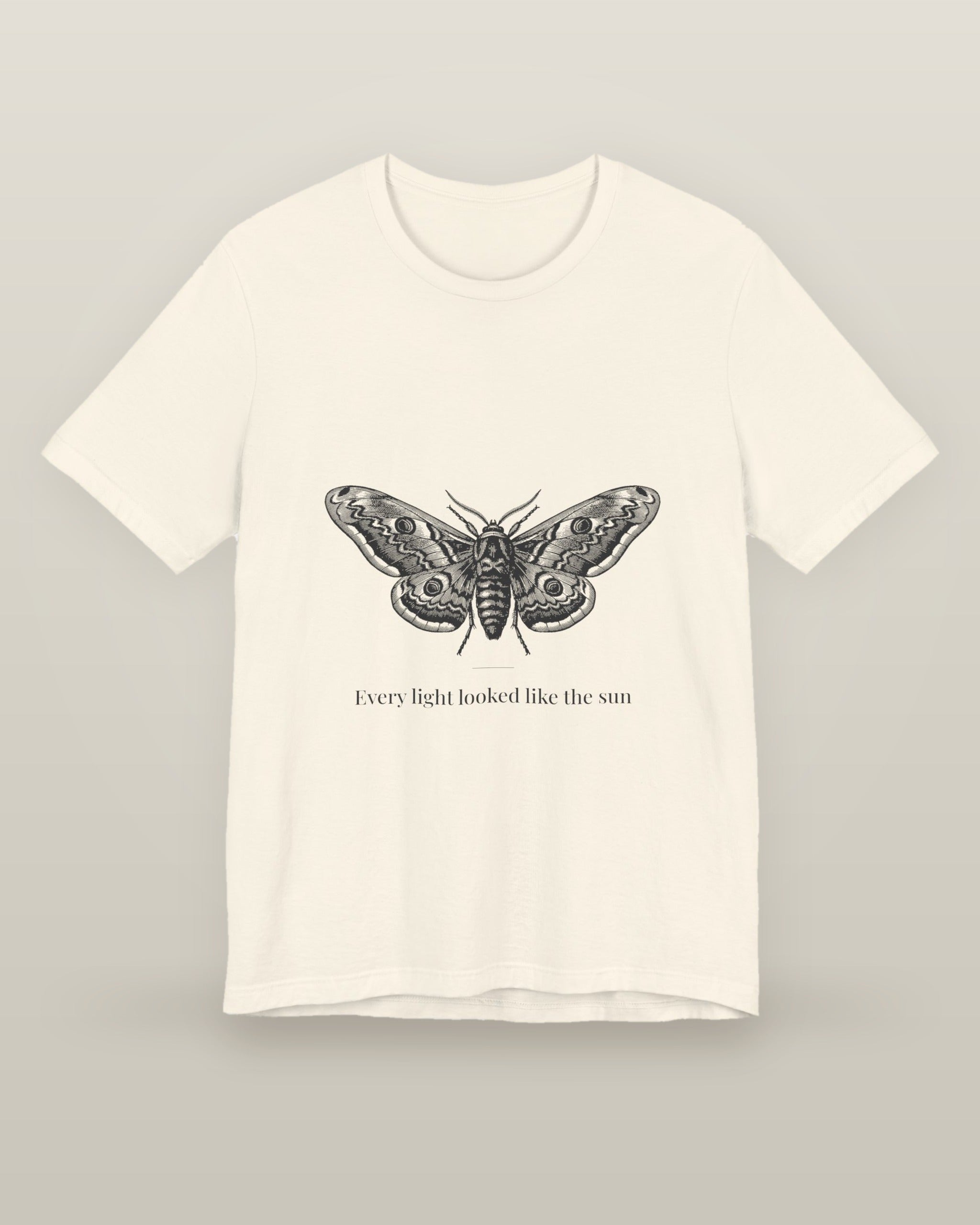 Every light looked like the sun — a moth specimen study, wings spread, printed on a natural cream cotton t-shirt, front view
