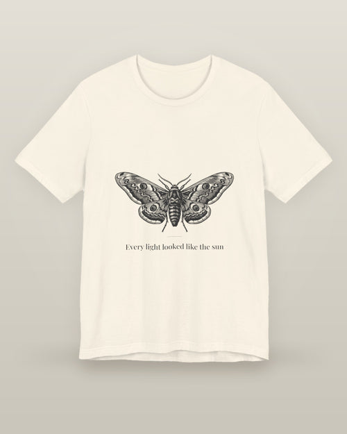 Every light looked like the sun — a moth specimen study, wings spread, printed on a natural cream cotton t-shirt, front view