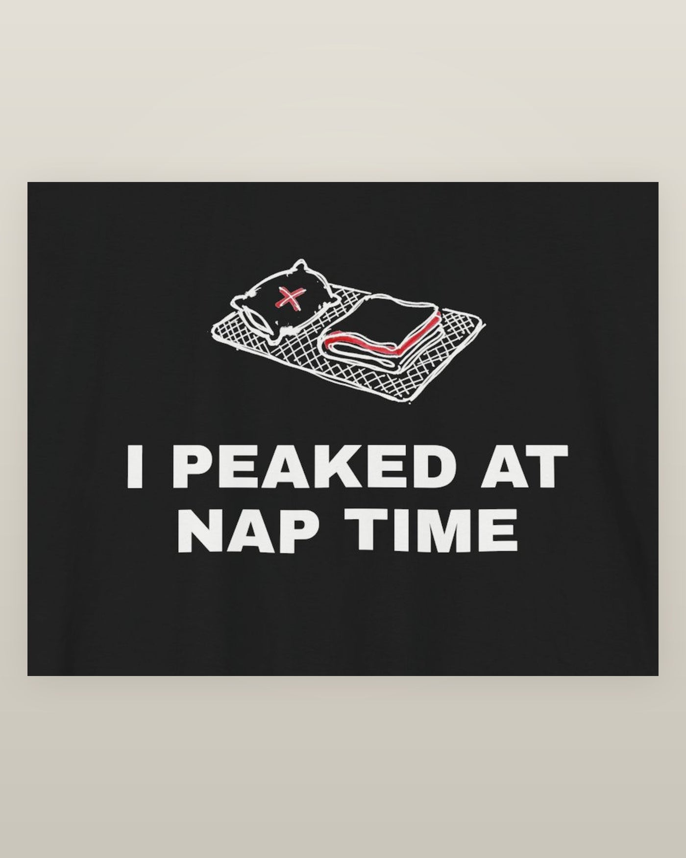 I peaked at nap time — a floor nap mat with a folded blanket and one pillow, printed on a black cotton t-shirt, close detail of the print