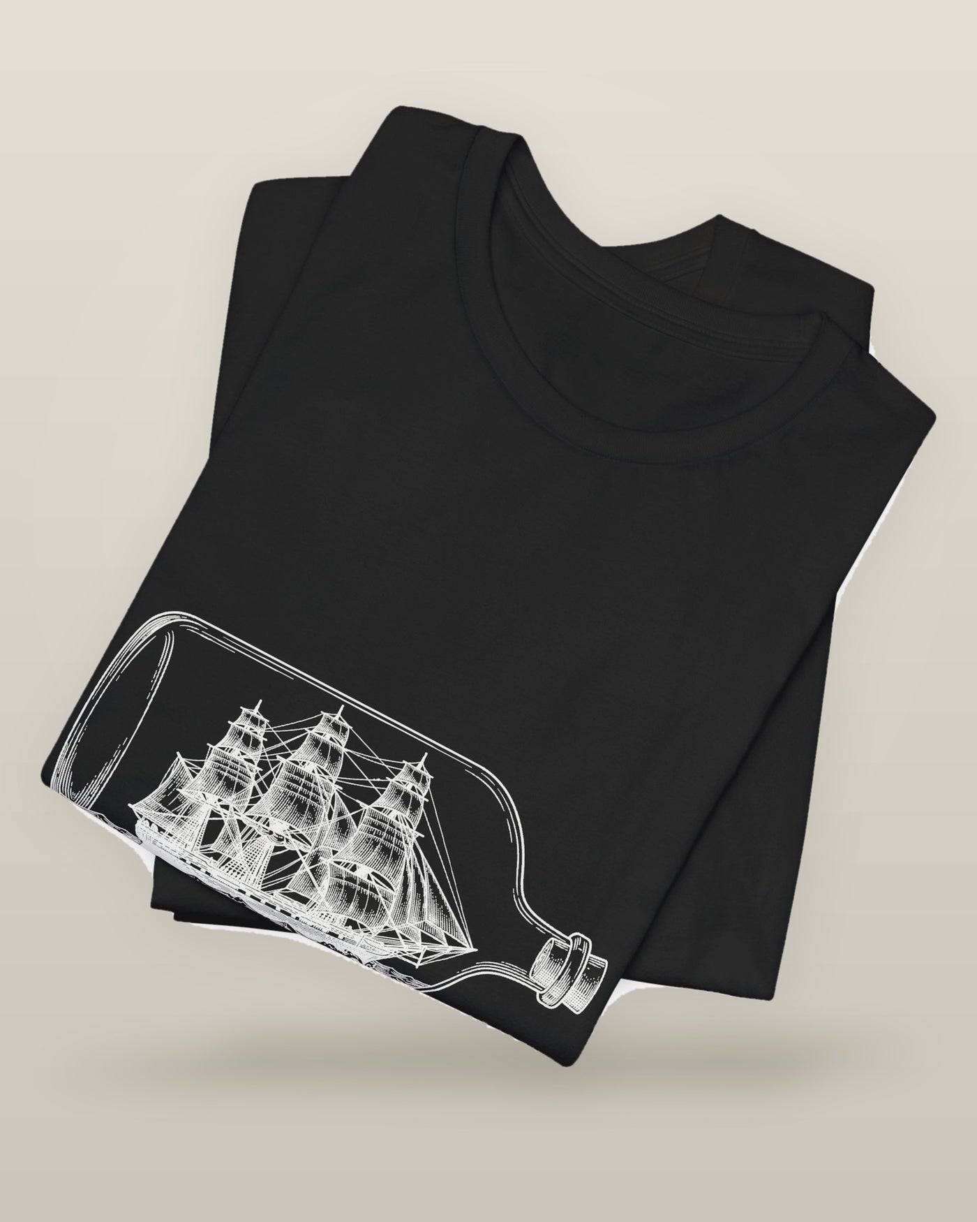 I called it the ocean — a full-rigged ship sealed in a glass bottle, printed on a black cotton t-shirt, folded
