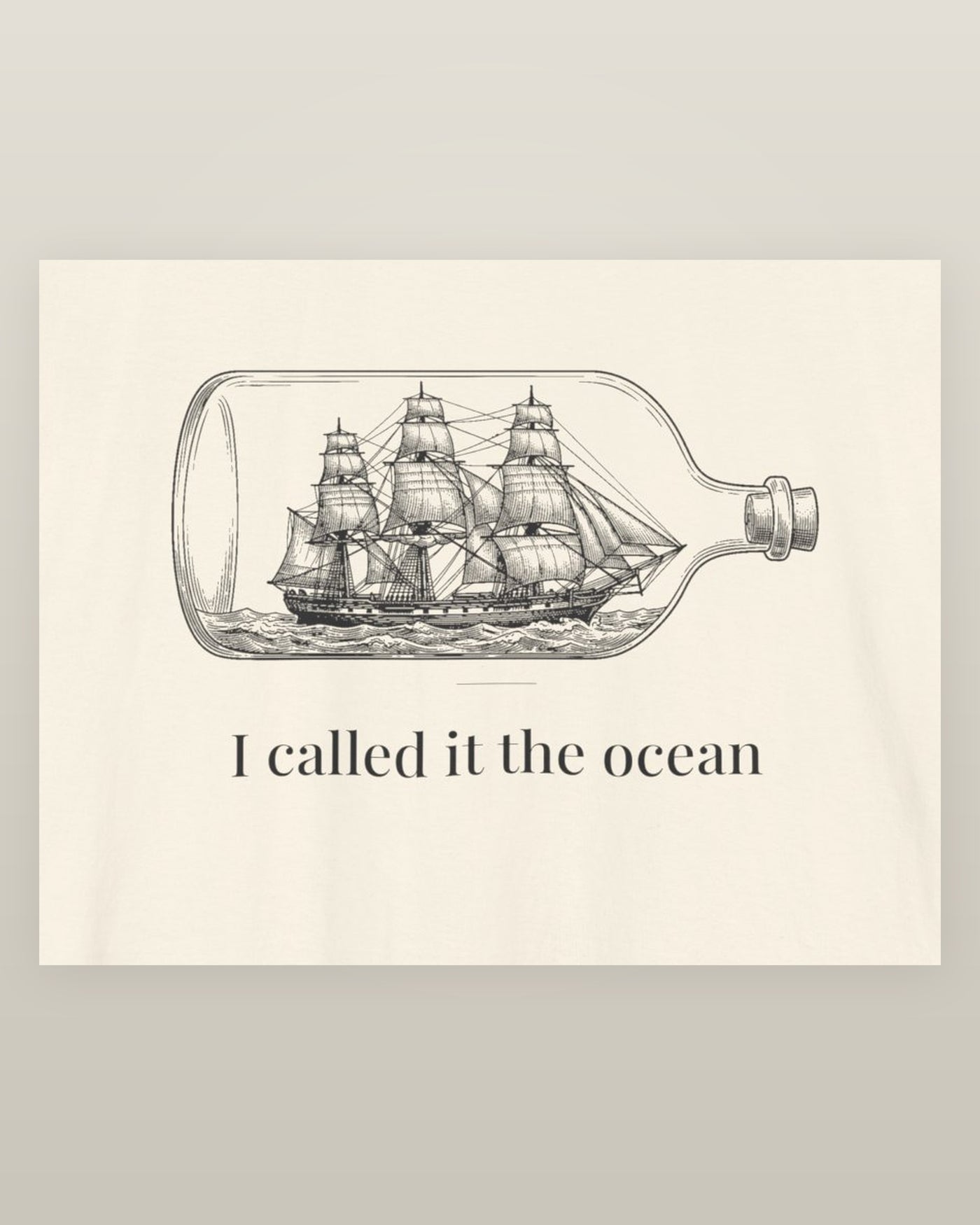 I called it the ocean — a full-rigged ship sealed in a glass bottle, printed on a natural cream cotton t-shirt, close detail of the print