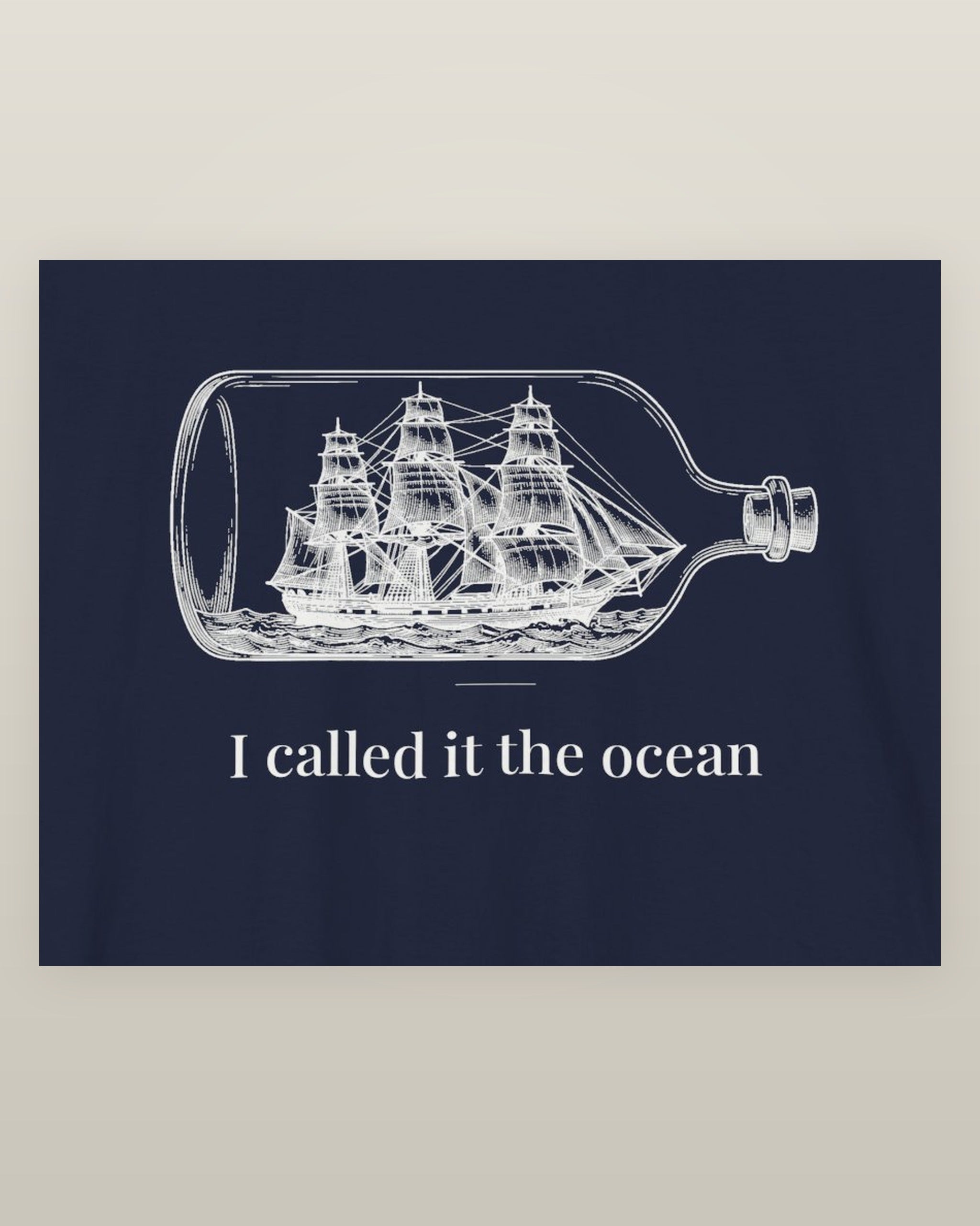 I called it the ocean — a full-rigged ship sealed in a glass bottle, printed on a navy cotton t-shirt, close detail of the print