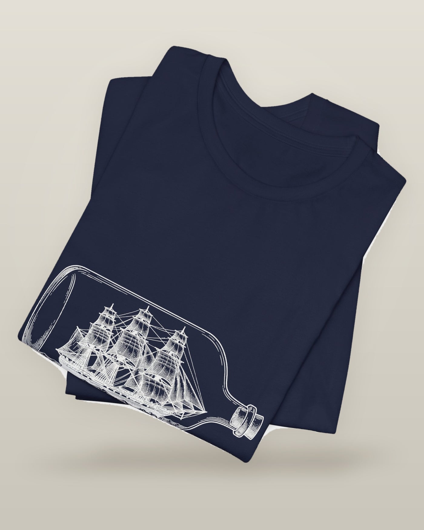 I called it the ocean — a full-rigged ship sealed in a glass bottle, printed on a navy cotton t-shirt, folded