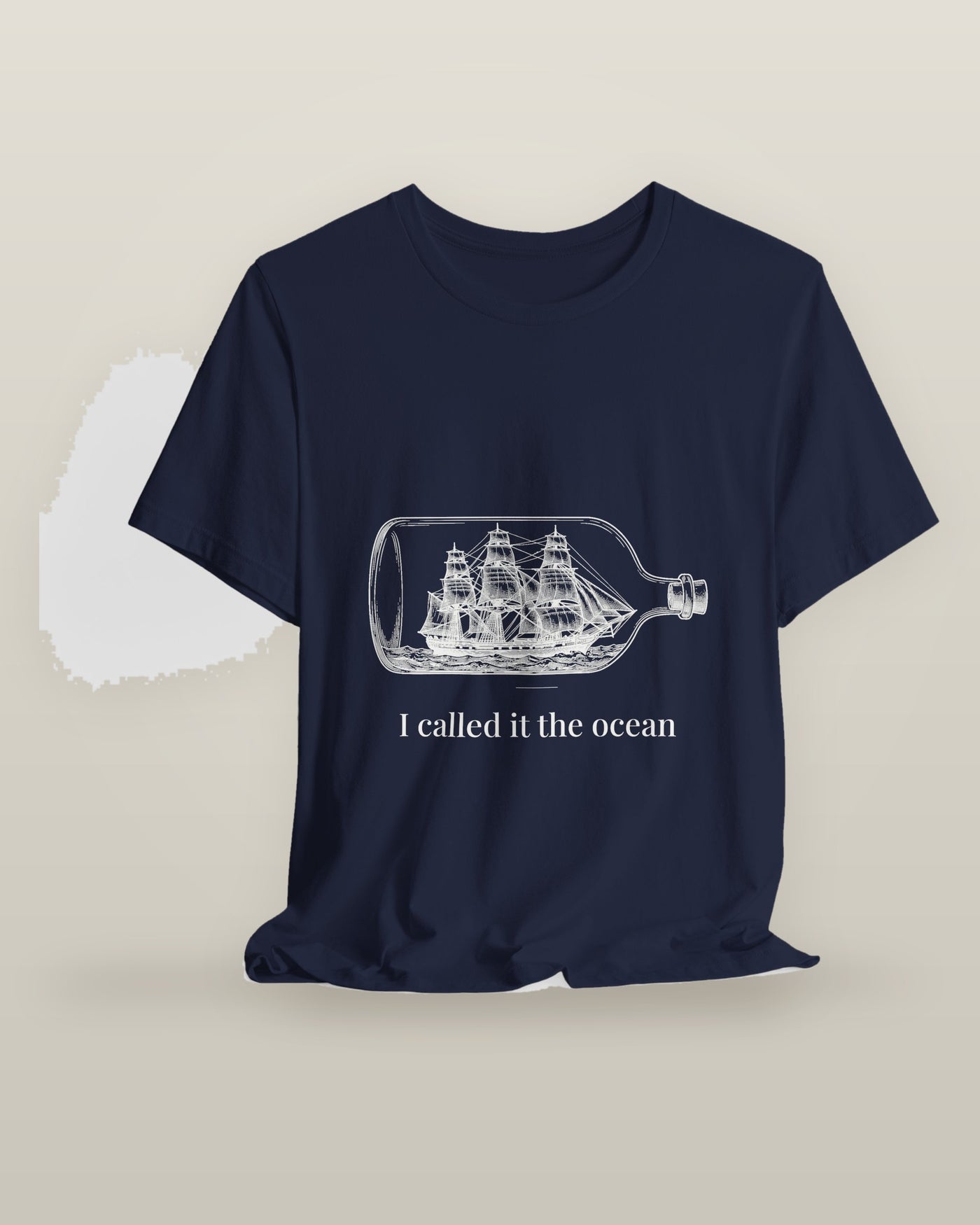 I called it the ocean — a full-rigged ship sealed in a glass bottle, printed on a navy cotton t-shirt, on a hanger