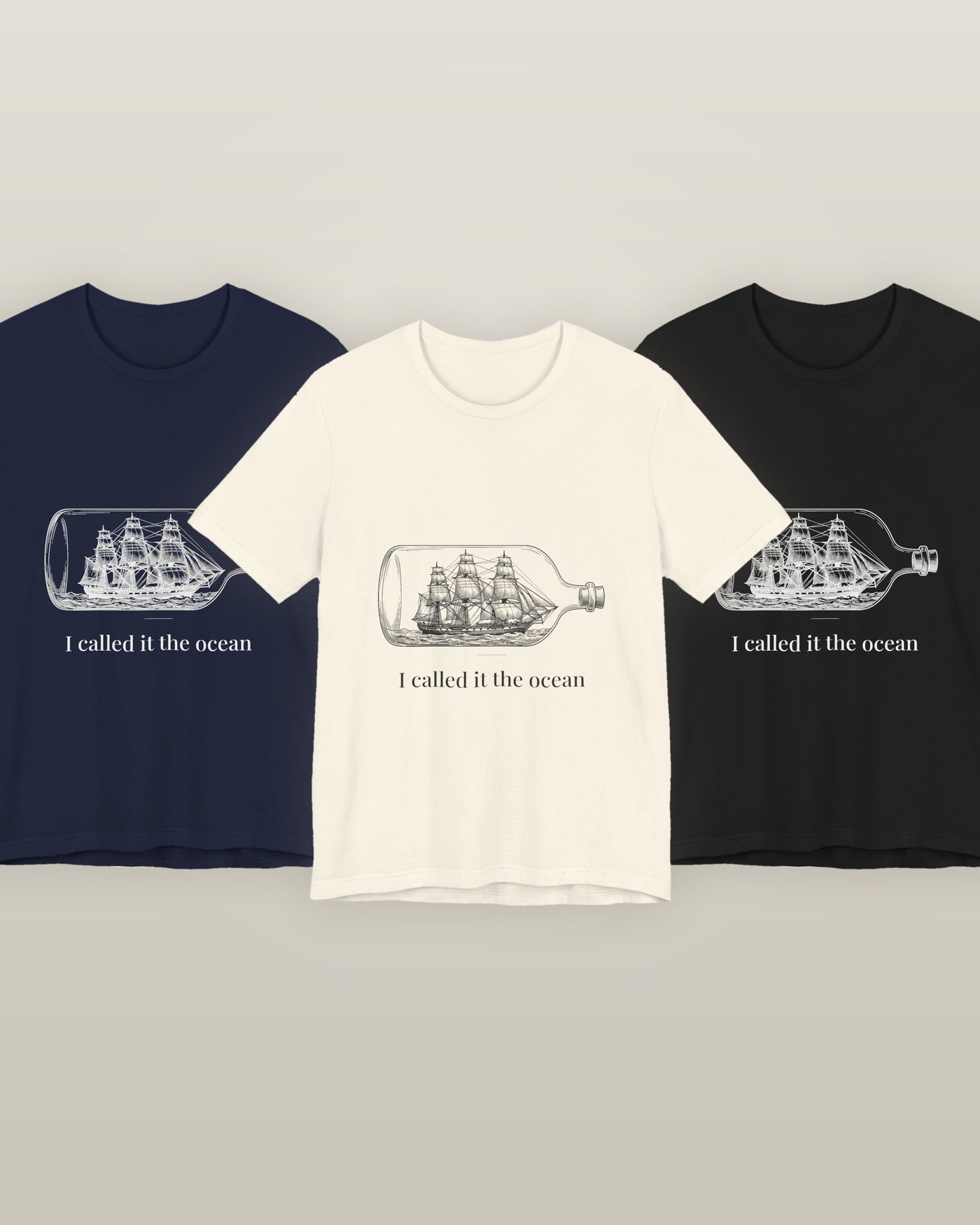 I called it the ocean — a full-rigged ship sealed in a glass bottle, printed on a natural cream, navy and black cotton t-shirt, all three colourways together