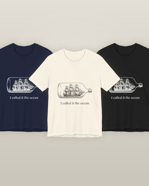 I called it the ocean — a full-rigged ship sealed in a glass bottle, printed on a natural cream, navy and black cotton t-shirt, all three colourways together