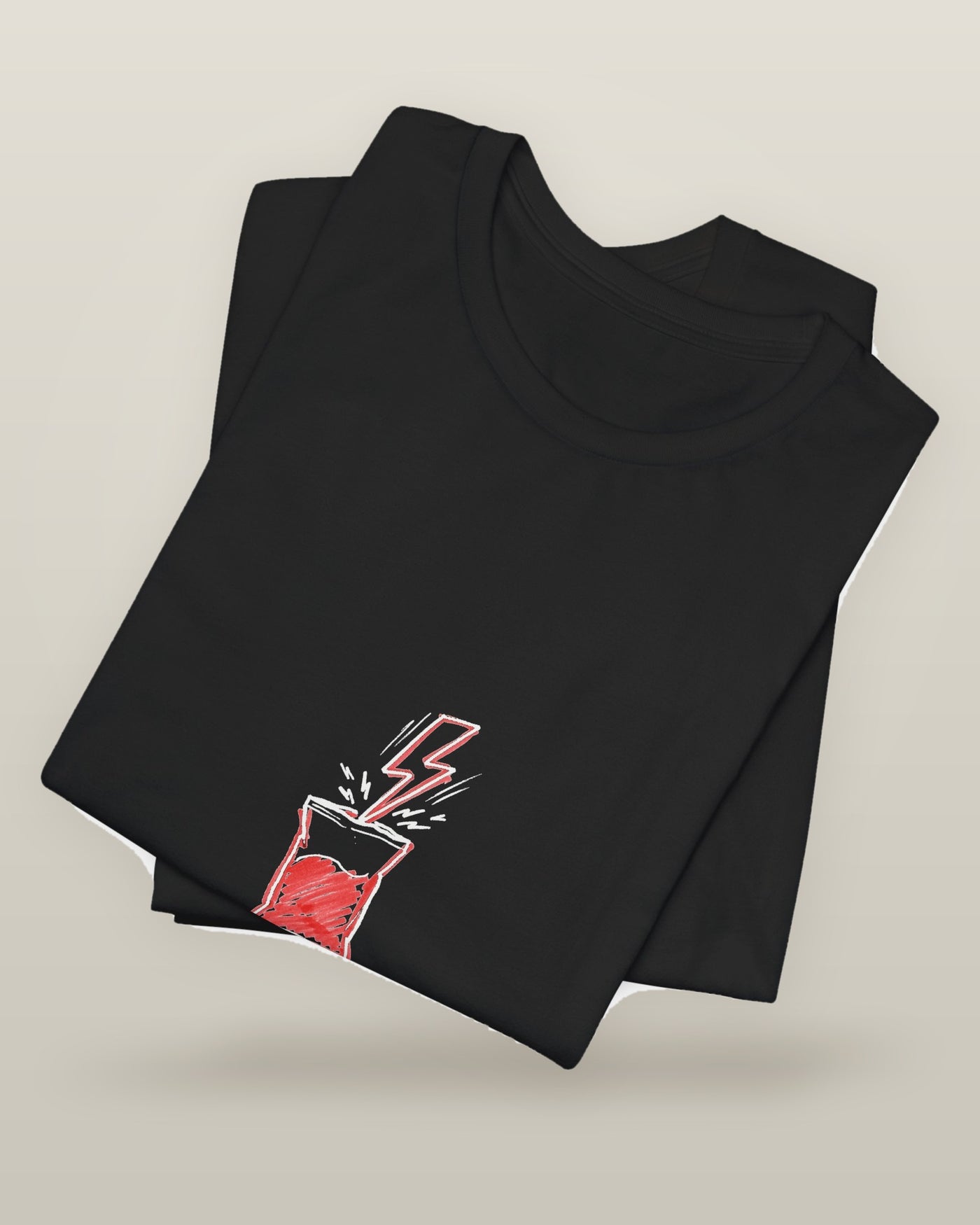 Powered by snacks and spite — a crisp packet struck by a lightning bolt, printed on a black cotton t-shirt, folded