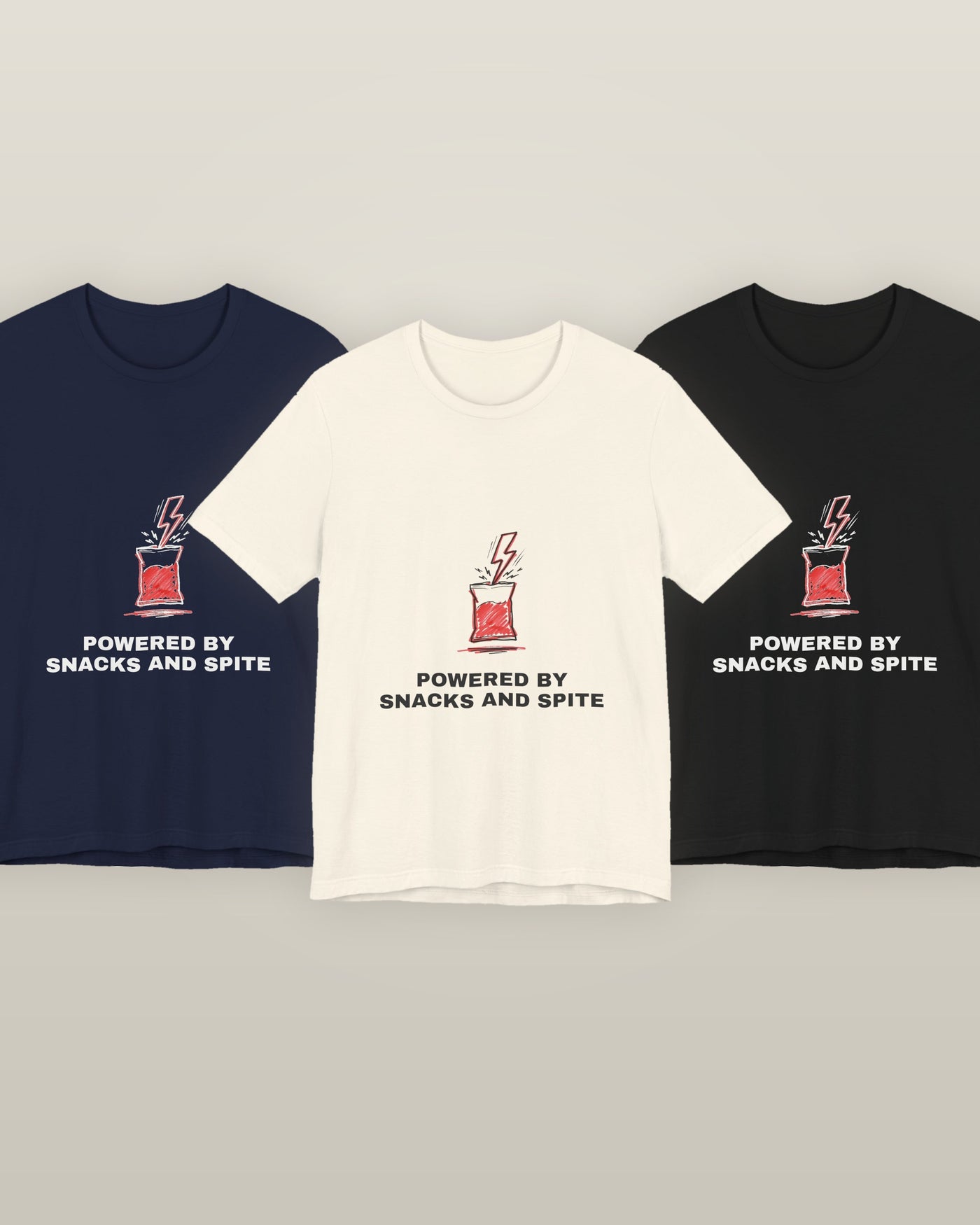 Powered by snacks and spite — a crisp packet struck by a lightning bolt, printed on a natural cream, navy and black cotton t-shirt, all three colourways together