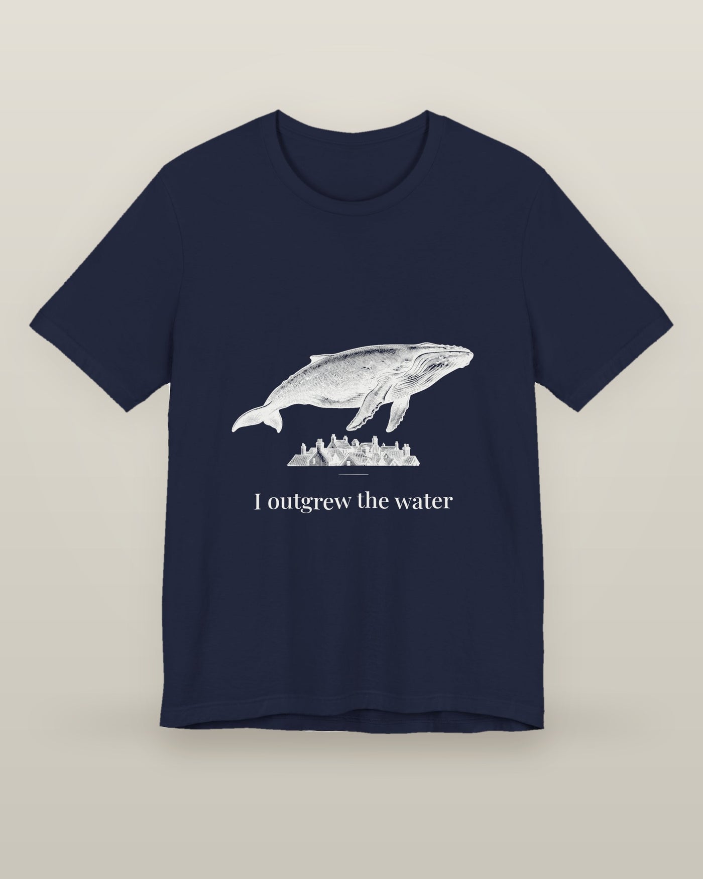 I outgrew the water — a humpback whale floating above rooftops, printed on a navy cotton t-shirt, front view