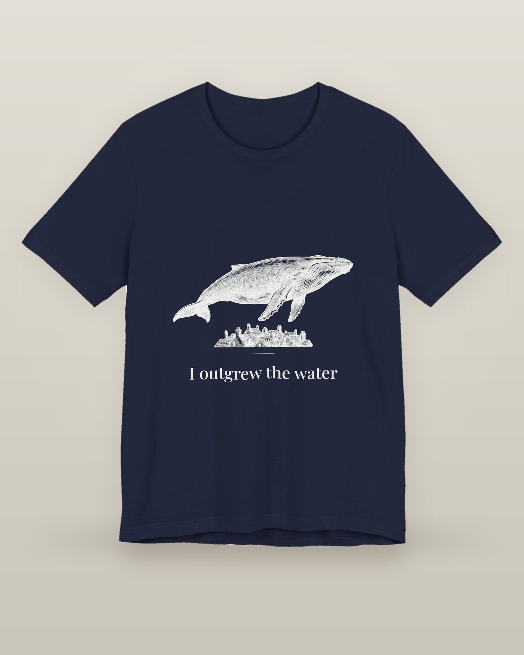 I outgrew the water — a humpback whale floating above rooftops, printed on a navy cotton t-shirt, front view